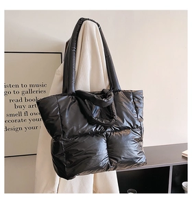 Close-up of black quilted puffer tote bag with glossy finish and square stitching