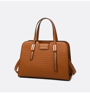 Detail view of brown crocodile embossed faux leather tote bag with double handles