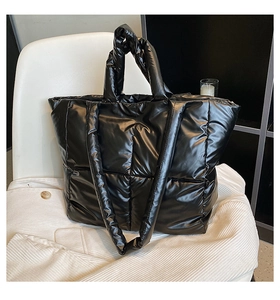 Detail of the black quilted puffer tote bag with glossy waterproof finish and soft texture