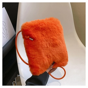 Close-up of bright orange faux fur crossbody bag with soft texture and leather strap