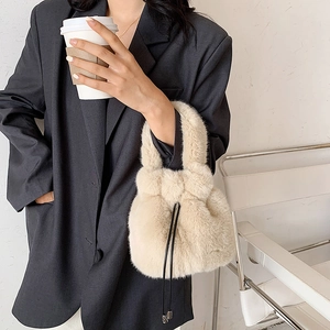 Chic beige faux fur drawstring bucket bag with plush texture for autumn and winter outfits