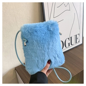 Close-up of a light blue plush faux fur crossbody bag with thin strap and silver hardware