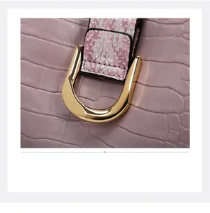 Macro shot of purple croc-embossed leather handbag with pink snake-print strap and gold D-ring