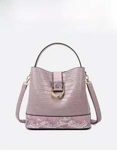 Detail of purple faux crocodile texture bag with pink snake pattern strap and golden D-ring