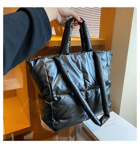 Close-up of black quilted down tote bag showing high-gloss waterproof nylon texture