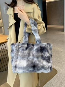 Sac fourre-tout d'hiver en fausse fourrure grise et blanche tenu par un mannequin