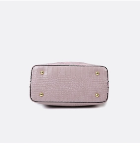 Detail of lavender crocodile embossed leather bag bottom with protective gold metal studs