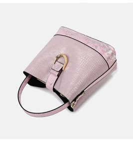 Detailed view of pink bucket bag with crocodile and snake skin textures and gold D-ring hardware