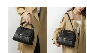 Detail of black crocodile texture handbag featuring gold hardware and versatile straps