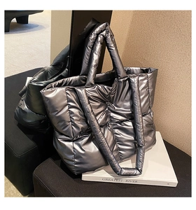 Detail of silver metallic quilted tote bag with padded texture and large capacity