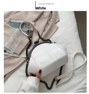 Detailed top view of a white shell-shaped quilted leather bag with elegant metal chain