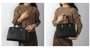 Detail shot of black crocodile texture handbag with metal logo and sturdy top handles