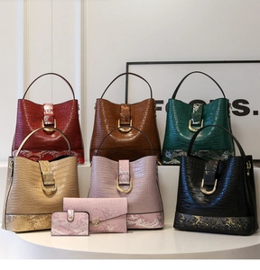 Close-up of crocodile and snakeskin textured bucket bags with golden horseshoe buckles