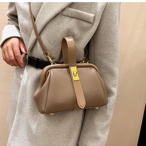 Close-up of brown litchi pattern leather doctor bag with golden metal clasp detail