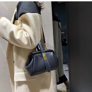 Litchi pattern leather bag with vintage metal frame and gold lock worn by model