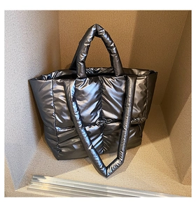 Macro detail of gunmetal padded tote bag showing wide square quilting and soft texture