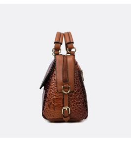 Detailed side profile of brown crocodile embossed handbag with gold hardware