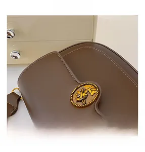Close-up of vintage gold floral metal ornament on brown textured leather bag