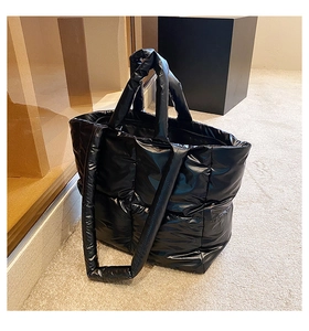 Close-up of black quilted down tote bag with high-gloss waterproof nylon finish