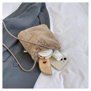 Brown plush crossbody bag for women with soft faux fur and slim strap on winter blazer