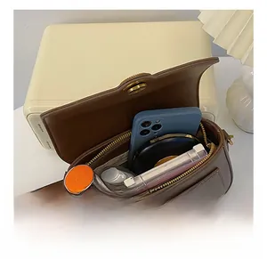 Interior view of small square bag showing storage capacity for phone and cosmetics