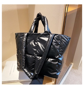 Detail of black puffer tote bag showing glossy quilted texture and spacious design