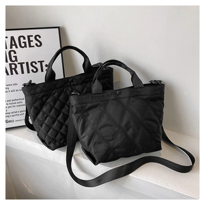 Dettaglio di borse tote in nylon trapuntato nero con ampie tracolle in tessuto regolabili