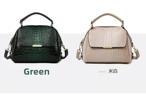Detail view of green and cream crocodile texture handbags with gold metal hardware