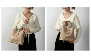 Close-up of beige crocodile texture bucket bag with gold horseshoe buckle detail