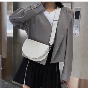 Sacoche blanche avec large bandoulière portée par un mannequin de style minimaliste