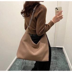 Détail du grand sac cabas camel avec plis verticaux et bandoulière en chaîne métallique