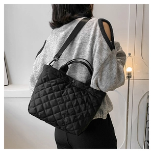 Borsa tote trapuntata con ricamo a rombi e ampia tracolla indossata da una modella