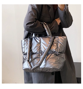 Macro view of metallic silver quilted down tote bag with classic large square stitching