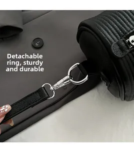 Detail of the detachable metal hook and durable D-ring on a black textured crossbody bag
