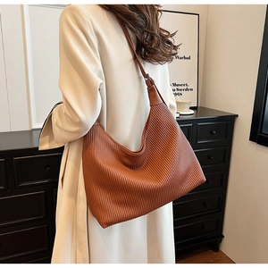 Détails de la texture plissée verticale d'un grand sac hobo marron en simili cuir
