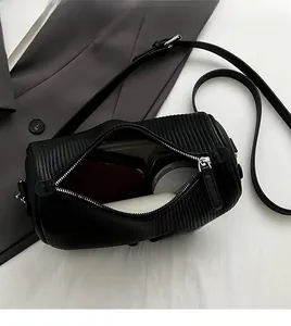 Top view of black cylindrical crossbody bag showing spacious interior and ripple texture