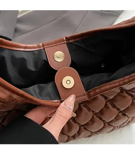Close-up of brown quilted bag with gold magnetic clasp and premium hardware detail