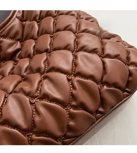 Detail shot of the caramel quilted faux leather texture with soft padded wave pattern