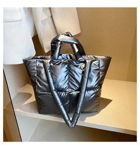 Detail of silver quilted padded tote bag featuring square stitching and metallic finish