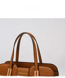 Detail display of brown embossed leather handbag with golden hardware and fashion logo