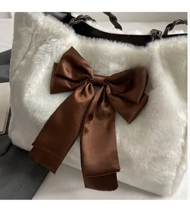 Close-up of plush white faux fur tote bag with a brown satin bow and woven leather handle