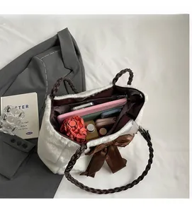 Spacious interior of white plush tote bag with woven handles and silk bow detail