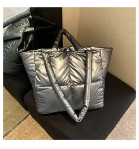 Detailed view of large quilted puffer tote bag with metallic dark silver finish and shoulder strap