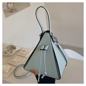 Détail d'un sac pyramide bleu clair en cuir lisse avec cordon de serrage et bandoulière