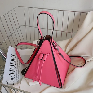 Détail du sac à main triangulaire rose vif avec bordures noires et cordon de serrage