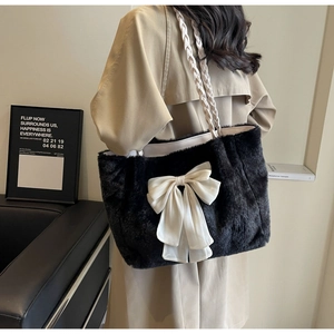 Detail of black faux fur tote bag with oversized white ribbon bow and woven handle