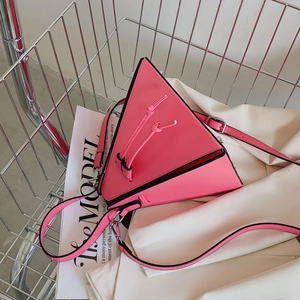 Détail du sac bandoulière triangulaire rose avec nœuds et bandoulière réglable en cuir