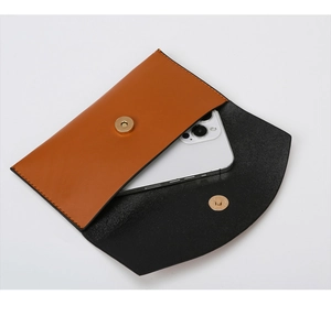 Detail of brown leather flap pouch with gold magnetic buckle and internal storage view