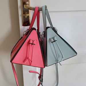Vue détaillée des sacs triangulaires rose et bleu avec cordon et texture cuir