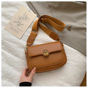 Close-up of retro brown messenger bag featuring lychee texture and brass relief buckle